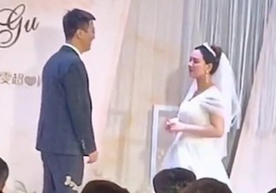 ​河南一婚礼现场新郎亲吻新娘用力太猛，遭新娘一把推开，场面尴尬